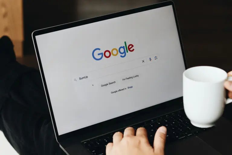 Ein Mann sucht am Laptop auf Google nach Flügen, Error Fares und Informationen, wie man günstig fliegen kann.
