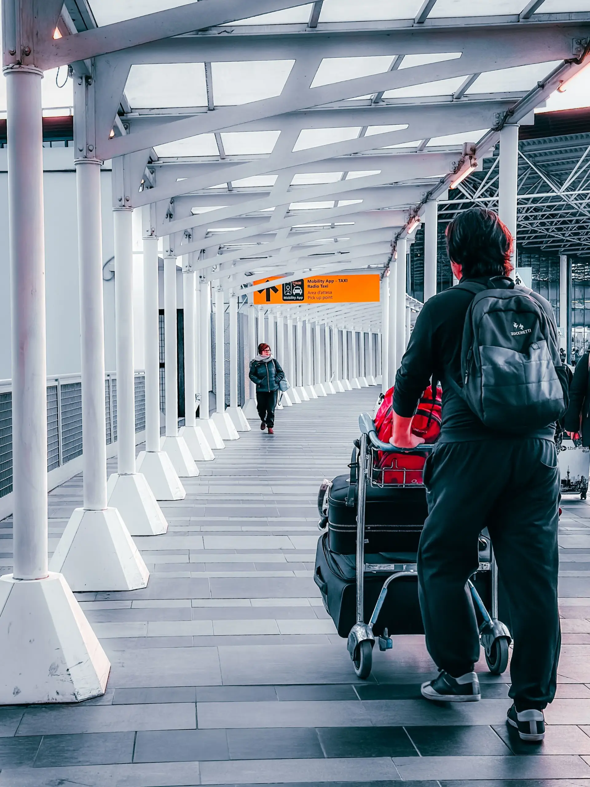 Reisender mit Gepäckwagen auf dem Weg zum Flughafenausgang gegen Jetlag nach der Landung in Sydney