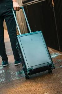 Ein Reisender zieht einen schwarzen Hartschalen-Trolley, der als Cabin Bag den erlaubten Lufthansa Handgepäck Maßen für das Fach über den Sitzen entspricht.