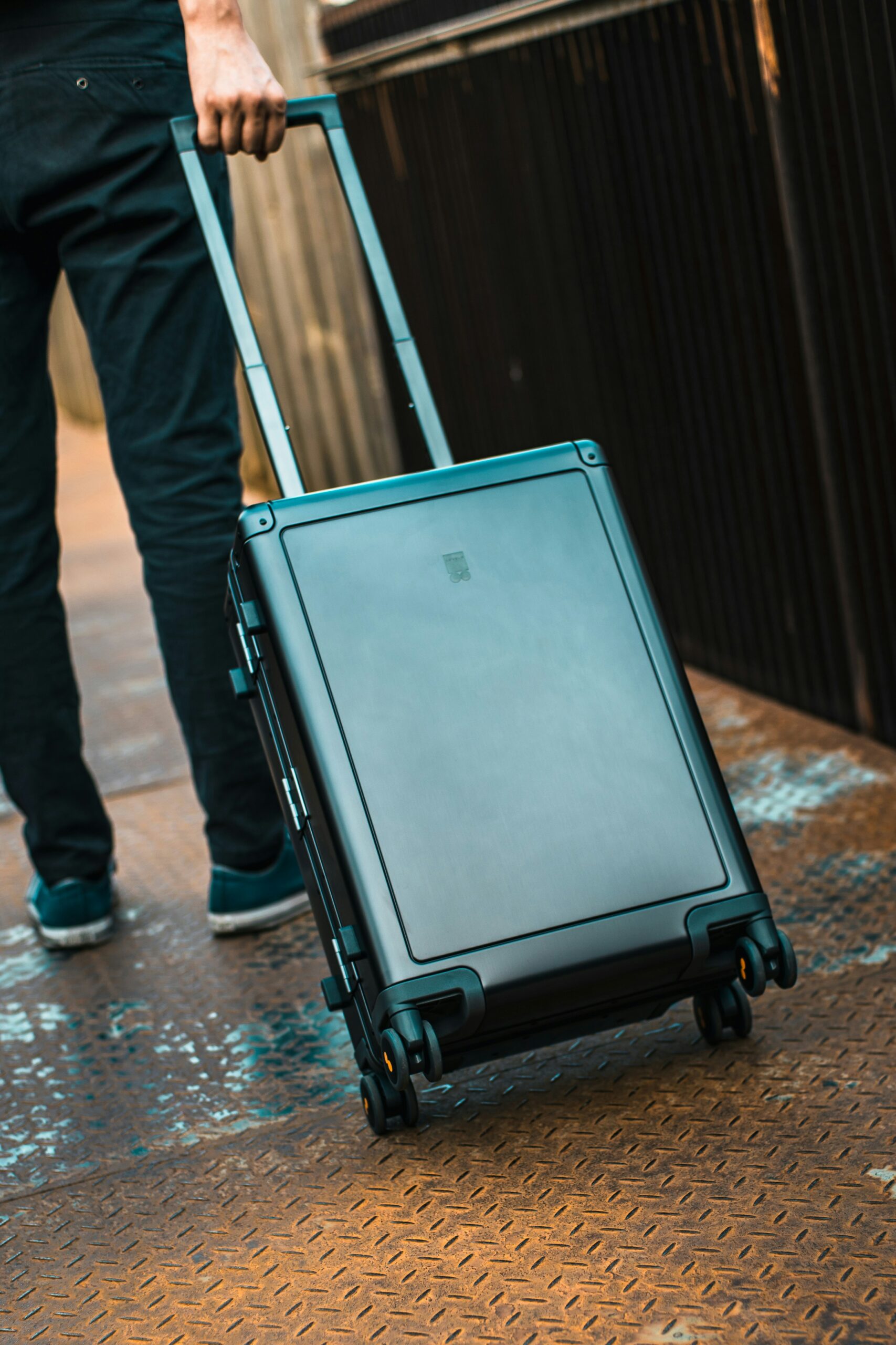 Ein Reisender zieht einen schwarzen Hartschalen-Trolley, der als Cabin Bag den erlaubten Lufthansa Handgepäck Maßen für das Fach über den Sitzen entspricht.
